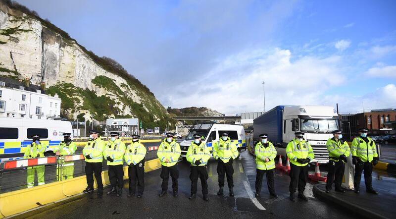 epa08900874 Police stand at the entrance of the Port of Dover after freight lorries cannot cross by sea or through the Eurotunnel and the Port of Dover has closed to outbound traffic in Dover, Britain, 23 December 2020. France closed its border with the UK for 48 hours over concerns about the new coronavirus variant. Lorry drivers must now obtain negative coronavirus tests before they will be allowed to cross by sea and the Port of Dover remains closed to outbound traffic on the morning of 23 December 2020.  EPA/FACUNDO ARRIZABALAGA