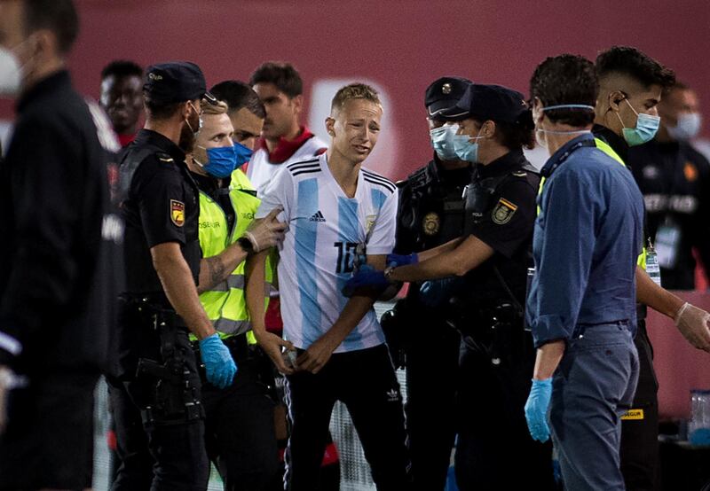 A pitch invader (C) is removed from the pitch. AFP