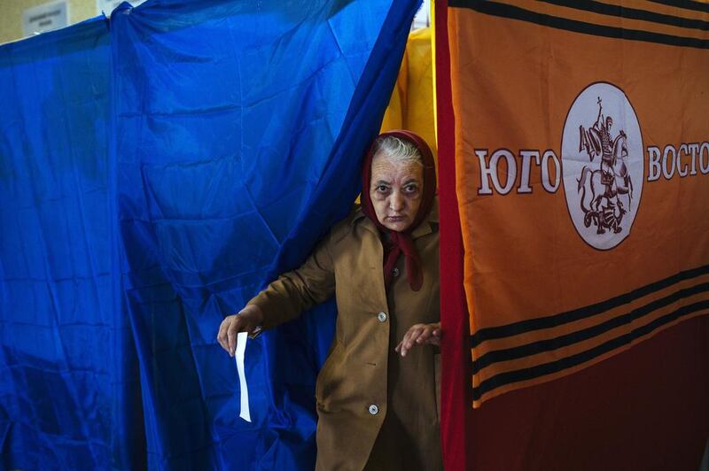 A woman steps out of a polling booth in a polling station in the village of Khryashchuvate. Dimitar Dilkoff/AFP