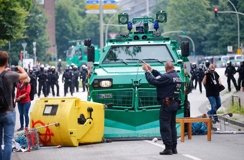 A German policeman stands in front of a barricade left by protesters. Hannibal Hanschke / Reuters