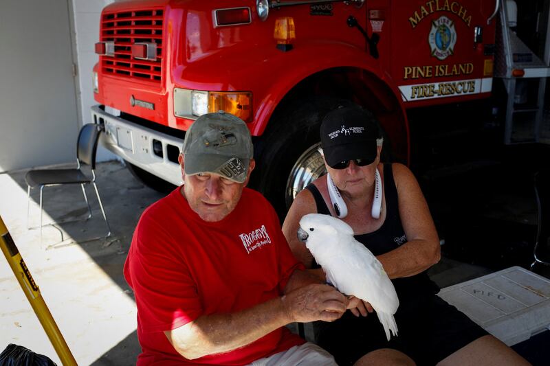 Mike Bailey and his wife Audrey with their cockatoo, Bailey, as they wait to be evacuated from Pine Island in Florida. Reuters