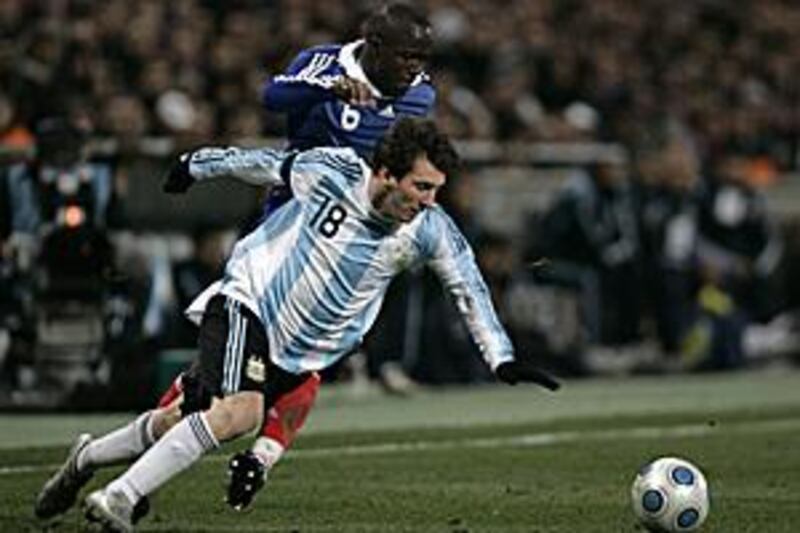 Argentina's Lionel Messi, front, stumbles past Lassana Diarra at the Stade Velodrome.