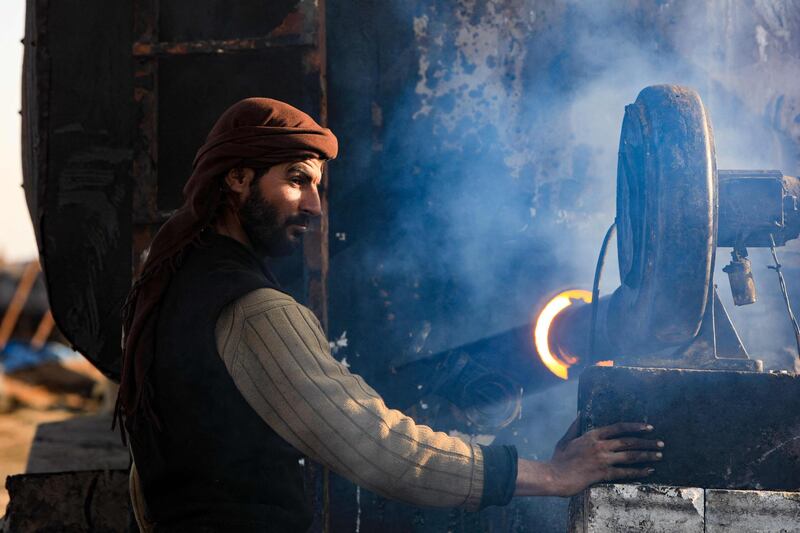 A man works at a makeshift oil refinery near Tarhin, Aleppo, Syria. Ordinary Syrians are refining crude oil into benzene, kerosene and diesel at these places. AFP