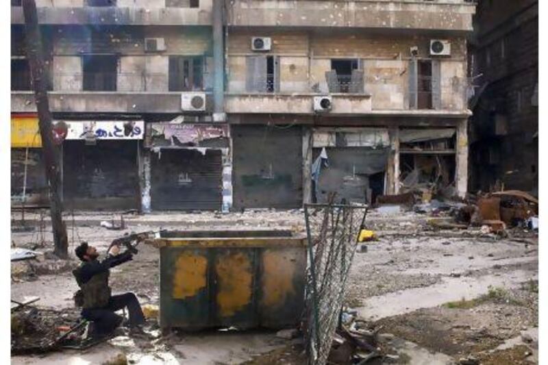 A Syrian rebel aims his weapon as he takes position behind a makeshift barricade in Aleppo. JM Lopez / AFP