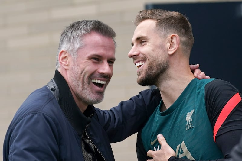 Liverpool's Jordan Henderson and former player James Carragher enjoy a joke at training. AP