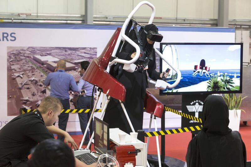 A show goer tries out the Martin Jetpack flight simulator while others watch at the 2015 Dubai Air show held at Dubai World Central. Antonie Robertson / The National