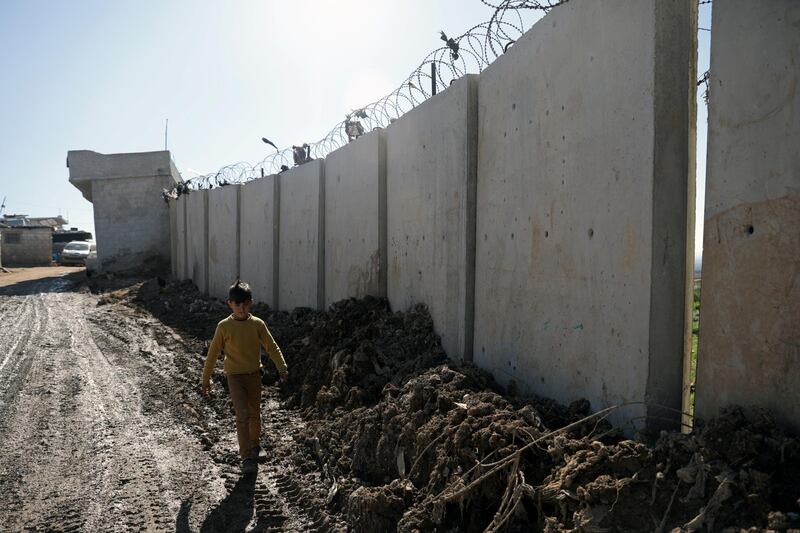 An internally displaced Syrian boy walks near the wall in Atmah IDP camp. Reuters