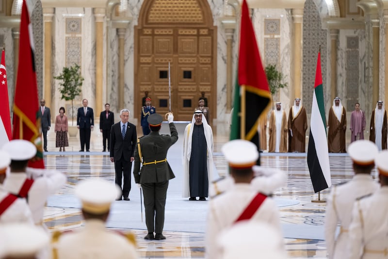 President Sheikh Mohamed and Mr Lee stand for the national anthems of the UAE and Singapore. Abdulla Al Neyadi / UAE Presidential Court