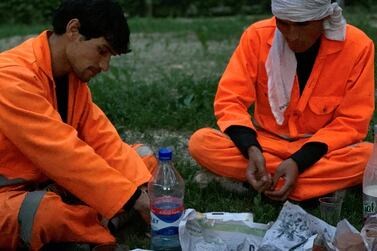 Municipality workers Zabihullah, left, and Fahim share their iftar in Kabul's Sharenaw Park.  Hikmatullah Noori for The National