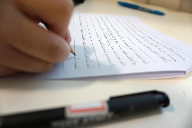 Students at Zayed University write in Arabic. Delores Johnson / The National  