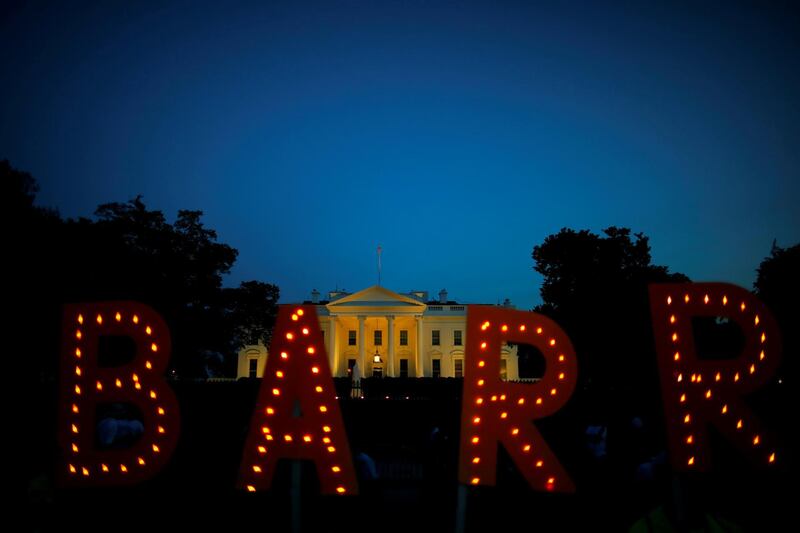 Protesters hold signs which read 'Barr' in reference to US Attorney General William Barr, following the release of the Mueller report on US President Donald Trump at the White House in Washington, U.S. Reuters