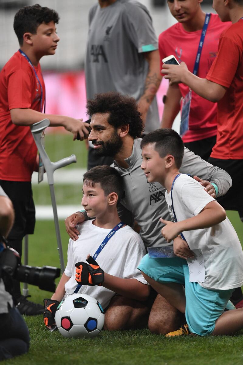 Mohamed Salah poses with children at the end of a training session ahead of the UEFA Super Cup 2019 match between Liverpool and Chelsea. AFP