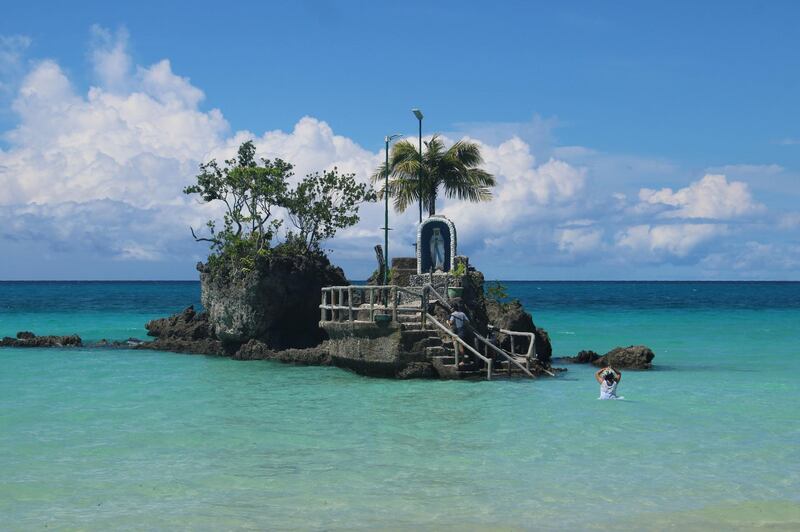 Residents visit the grotto of the Virgin Mary at Willy's rock on a beach in Borocay, central Philippines. AFP