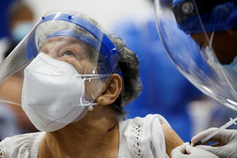 A woman reacts as she receives the first dose of China's Sinovac Biotech vaccine, during a mass vaccination programme for the elderly, at the Bolivarian Technology Institute in Guayaquil, Ecuador. Reuters