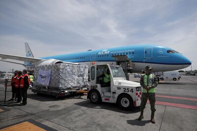 Workers unload a batch of AstraZeneca coronavirus disease (COVID-19) vaccines, delivered under the COVAX scheme, from a KLM Boeing 787 at Benito Juarez International Airport in Mexico City, Mexico May 27, 2021. REUTERS/Henny Romero