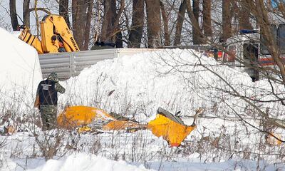 A man looks at wreckage near the scene of a AN-148 plane crash in Stepanovskoye village, about 40 kilometers (25 miles) from the Domodedovo airport, Russia, Monday, Feb. 12, 2018. A Russian passenger plane carrying 71 people crashed Sunday near Moscow, killing everyone aboard shortly after the jet took off from one of the city's airports. The Saratov Airlines regional jet disappeared from radar screens a few minutes after departing from Domodedovo Airport en route to Orsk, a city some 1,500 kilometers (1,000 miles) southeast of Moscow. (AP Photo/Alexander Zemlianichenko)