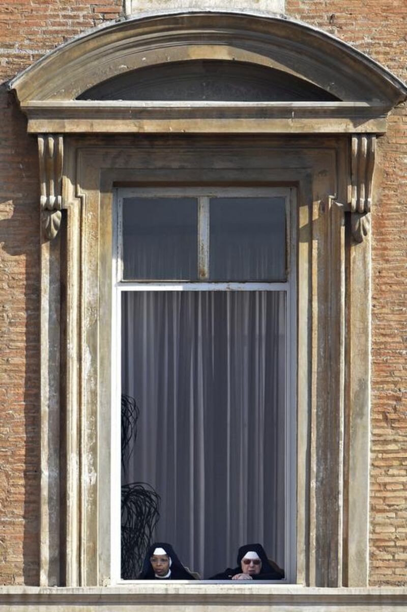 Nuns stand at a window before the Easter Sunday mass at St Peter’s square in Vatican. Christians around the world are marking the Holy Week, commemorating the crucifixion of Jesus Christ, leading up to his resurrection on Easter. Andreas Solaro / AFP