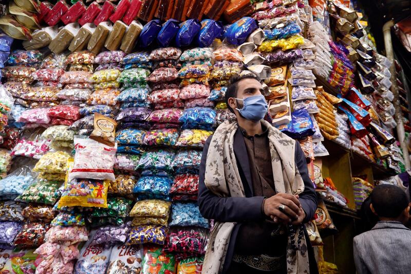 A vendor wearing a protective face mask waits for customers ahead Eid Al Fitr, in Sanaa, Yemen, May 20, 2020. EPA