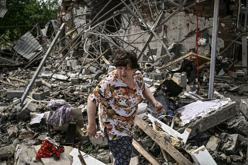 A woman looks for her belongings beneath rubble after a strike destroyed three houses in the city of Slovyansk, in the Ukrainian region of Donbas. AFP