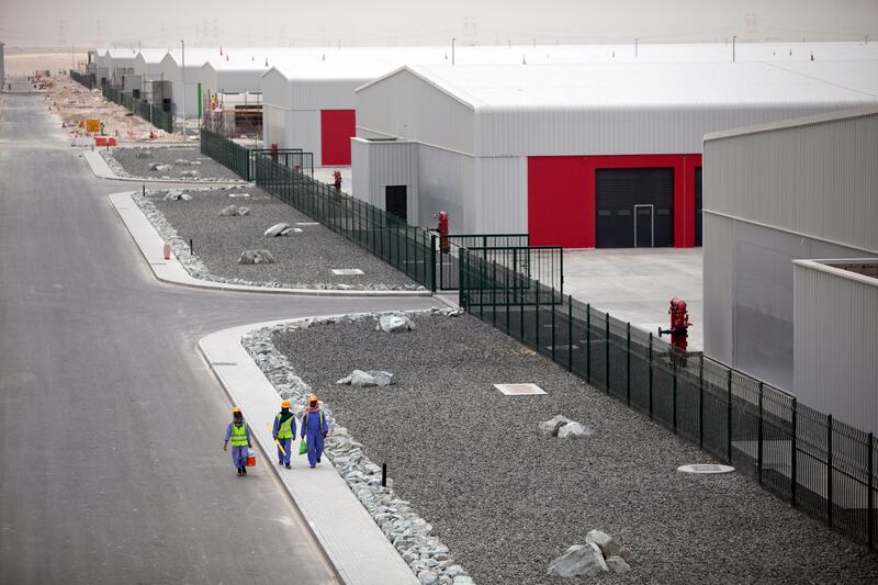United Arab Emirates, near Abu Dhabi, April 2, 2012:   
Laborers walk past warehouses at the ALMARKAZ industrial development near Abu Dhabi, the first project of Waha Land, a Waha Capital subsidiary. The project has nine warehouses already with 90,000 square meters available in total in the first phase of the development.  (Silvia Razgova / The National)
