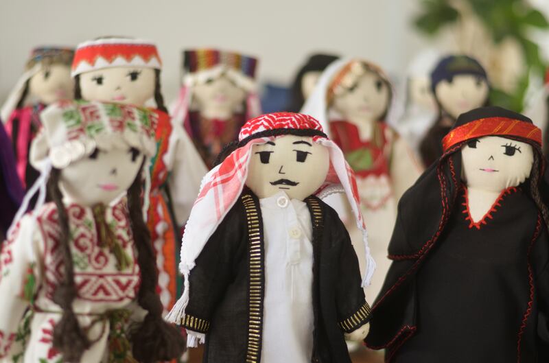Dolls wearing Jordanian and Palestinian traditional costumes are displayed as part of the 'Madeena the Doll' project.