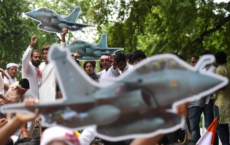 Supporters of the opposition Indian National Congress party hold models of fighter planes as they shouts slogans during a protest against a Rafale jets deal. AFP