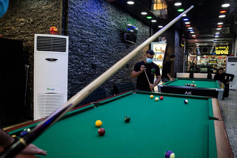 Men wearing protective face masks play pool at a near empty pool house in Najaf, Iraq. On September 4, Iraq recorded 5,036 coronavirus cases, its biggest daily increase since the start of the outbreak.  The surge has prompted warnings from Iraq's health minister and WHO that the country could be on the verge of a health crisis as pressure mounts on the already strained healthcare system. Since the first case was recorded in February, Iraq has recorded 252,075 total cases and 7,359 deaths. Getty Images