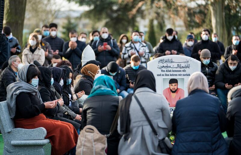 People gather at the grave of Ferhat Unvar, Hamza Kurtovic and Said Nesar Hashemi, three of the victims, at the memorial service. Getty Images