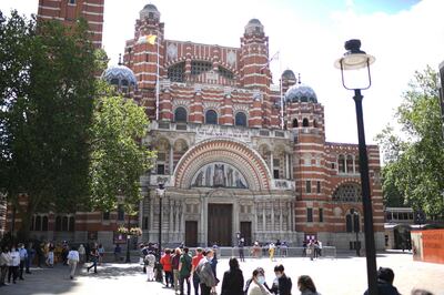 Worshippers queue to enter Westminster Cathedral in London on July 5, 2020 for Sunday Mass on the first Sunday since coronavirus lockdown restrictions were eased to allow for communal prayer.  The Christian devotee is a regular at Westminster Cathedral and has been attending services with her statue of Jesus sitting atop the globe for 26 years. Churches opened their doors for Sunday Mass for the first time in months since the coronavirus restrictions were eased in England.  / AFP / DANIEL LEAL-OLIVAS
