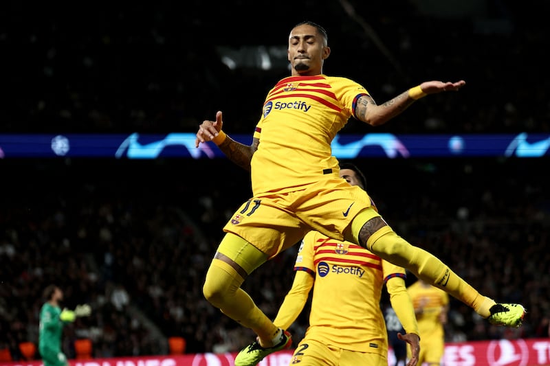 Raphinha leaps in celebration after scoring his second goal for Barcelona to level the score at 2-2 against PSG. AFP