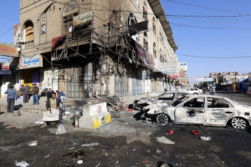 Yemenis gather near destroyed vehicles at a street leading to the residence of Yemen’s ex-president Ali Abdullah Saleh a day after Houthi militants killed him, in Sana’a, Yemen. Yahya Arhab / EPA