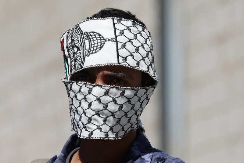 A member of Yemen's Houthi militia covers his face with a Palestinian scarf during a rally in Sanaa this week. EPA