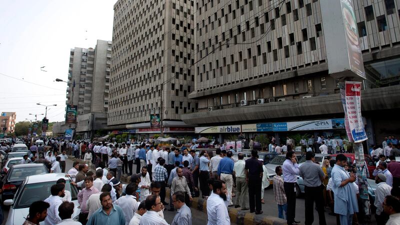 People evacuate buildings and gather on road after a tremor of an earthquake was felt in Karachi, Pakistan, Tuesday, April 16, 2013. A major earthquake described as the strongest to hit Iran in more than half a century flatted homes and offices Tuesday near Iran's border with Pakistan, killing at least tens of people in the sparsely populated region and swaying buildings as far away as New Delhi and the skyscrapers in Dubai and Bahrain. (AP Photo/Shakil Adil) *** Local Caption ***  Pakistan Quake.JPEG-004a1.jpg