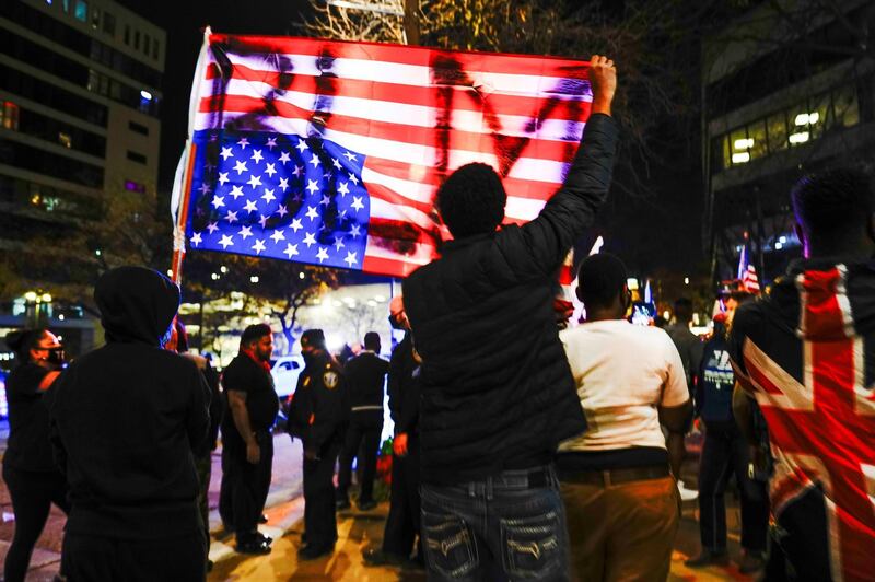 Black Lives Matter (BLM) counterprotesters hold up an inverted US flag in a 'Stop the Steal' protest outside Milwaukee Central Count, in Milwaukee, Wisconsin. Reuters