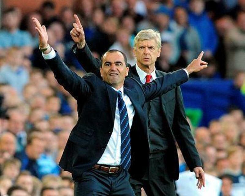 Everton's manager Roberto Martínez, left, and Arsenal's manager Arsene Wenger react during the English Premier League soccer match between Everton and Arsenal at Goodison Park, in Liverpool, England, Saturday, Aug. 23, 2014. (AP Photo/Rui Vieira)



