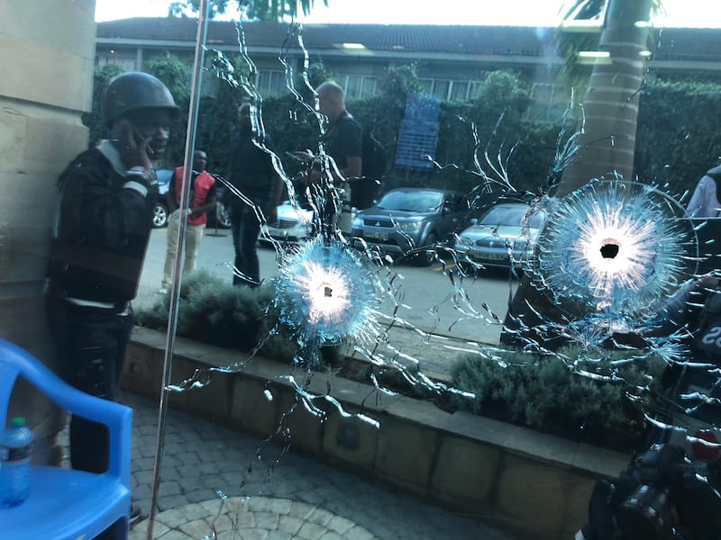 An armed soldier takes cover next to a bullet-riddled window. Dai Kurokawa / EPA