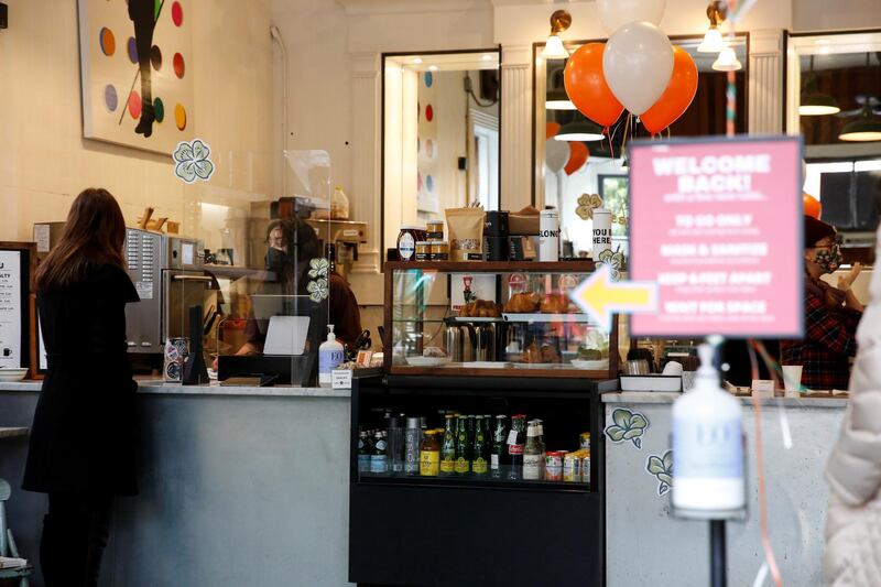 A barista works behind the counter taking orders from guests as Farley's Cafe marks its 32nd anniversary with bagpipes, Irish stew, and live music on St. Patrick's Day in San Francisco, California, U.S. March 17, 2021. REUTERS/Brittany Hosea-Small