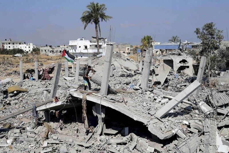 A Palestinian man searches for his belongings from the remains of his house, which witnesses said was destroyed in the Israeli offensive, during a 72-hour truce in Khan Younis, in the southern Gaza Strip on August 12. Ibraheem Abu Mustafa / Reuters