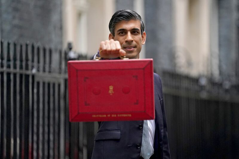 Britain's Chancellor of the Exchequer Rishi Sunak poses with the Budget box as he leaves No 11 Downing Street in London. The UK economy is set to grow 6.5 per cent this year but rising inflation poses a risk. PA