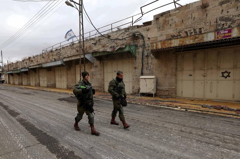 epa08039670 Israeli soldiers walk on Shuhada Street near the Ibrahimi Mosque or the Tomb of the Patriarch, holy for both Jews and Muslims, in the West Bank town of Hebron, 02 December 2019. According to media reports, Israeli Minister of Defense Naftali Bennett on 01 December announced plans of a new Jewish neighborhood in Hebron.  EPA/ABED AL HASHLAMOUN