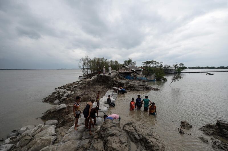 Volunteers and residents work to repair a damaged dam following the landfall of cyclone Amphan in Burigoalini. At least 84 people died as the fiercest cyclone to hit parts of Bangladesh and eastern India this century sent trees flying and flattened houses, with millions crammed into shelters despite the risk of coronavirus.  AFP