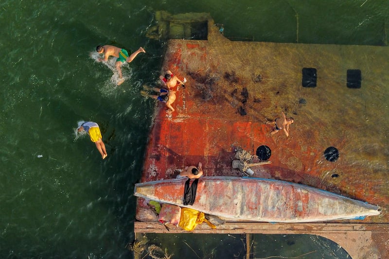 Children swimming next to a sunken vessel in the Shatt Al Arab river, formed at the confluence of the Tigris and Euphrates, in Basra, Iraq. AFP