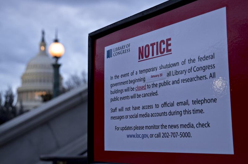 The U.S. Capitol stands past a temporary shutdown sign outside the Library of Congress in Washington, D.C., U.S., on Sunday, Jan. 21, 2018. The House and Senate are back in session Sunday with a federal government shutdown in its second day amid a spending-bill impasse in Congress. The House is supposed to be on recess this week, but members stayed in Washington as negotiations continue. Photographer: Andrew Harrer/Bloomberg