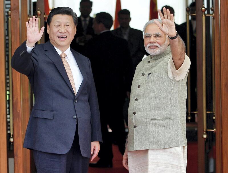 India's Prime Minister Narendra Modi (R) and China's President Xi Jinping wave before their meeting in the western Indian city of Ahmedabad September 17, 2014. Xi arrived in India as the two Asian giants take steps to boost commercial ties. China has pledged to invest billions of dollars in Indian railways, industrial parks and roads, but ties between the nuclear-armed nations have long been held back by distrust, mostly over their contested border. REUTERS/Amit Dave (INDIA - Tags: POLITICS PROFILE TPX IMAGES OF THE DAY) - RTR46K72