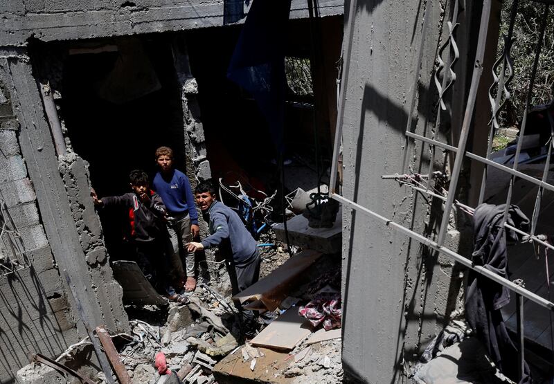 Palestinians inspect a house damaged in an Israeli strike. Reuters
