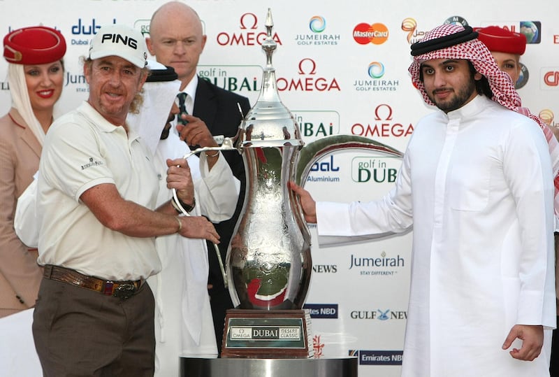 Spain's Miguel Angel Jimenez (L) receives his trophy from Sheikh Ahmed bin Mohammed bin Rashed al-Maktoum (R), son of Dubai ruler Sheikh Mohammed bin Rashed al-Maktoum, after winning the Dubai Desert Classic golf championship in the Gulf emirate on February 7, 2010. Jimenez won the Dubai Desert Classic for the first time, defeating European No.1 Lee Westwood on the third hole of a drama-packed playoff. AFP PHOTO/KARIM SAHIB (Photo by KARIM SAHIB / AFP)
