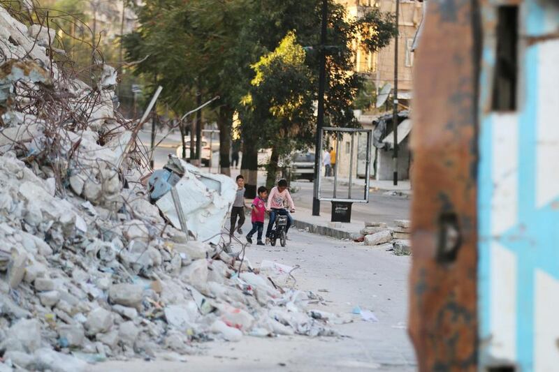Children play with a bicycle near the rubble of damaged buildings in the rebel-held Bab al-Hadid neighbourhood of Aleppo, Syria, September 14, 2016. REUTERS/Abdalrhman Ismail