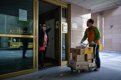 In a photo taken on May 10, 2018 Park Jae-yeol (R) greets a resident as he makes his rounds delivering packages at an apartment complex in Seoul. In theory Park Jae-yeol should have retired 11 years ago. But despite its advanced-economy status, South Korea's pensions are meagre and the 71-year-old supplements his by delivering packages to high-rise apartments. Park is one of millions of elderly South Koreans pushed to labour well past retirement age in a rapidly-ageing society with weak social safety nets.
 - To go with SKorea-economy-population-social-demographics, FOCUS by Jung Hawon
 / AFP / Ed JONES / To go with SKorea-economy-population-social-demographics, FOCUS by Jung Hawon
