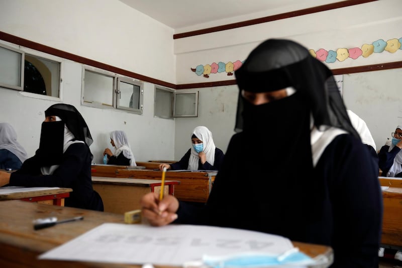 Yemeni students wearing protective face masks take final school exams at a public school in Sana'a, Yemen.   EPA