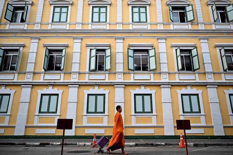 A Buddhist monk walks barefoot past Thailand's Ministry of Defence in Bangkok. AFP
